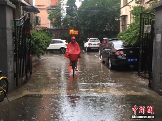 6月23日清晨，北京降雨持续，并出现了短时大雨。据北京市气象局官方微博消息，北京市气象台今日6时发布：今天白天小到中雨并伴有雷电，傍晚局地伴有短时大风或冰雹，北转东风2、3级，最高气温24℃；夜间有雷阵雨，东转北风2、3级，最低气温19℃。北京百万庄附近，市民雨中骑行。 中新网记者 富宇 摄