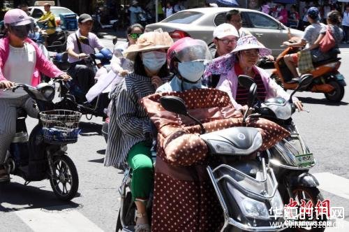 7月10日，福建省福州市民出行“全副武装”抵挡酷暑。 刘可耕 摄