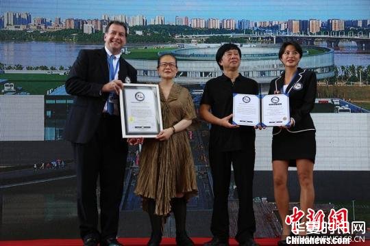 李自健夫妇从世界纪录认证官手中接过证书。　刘享 摄
